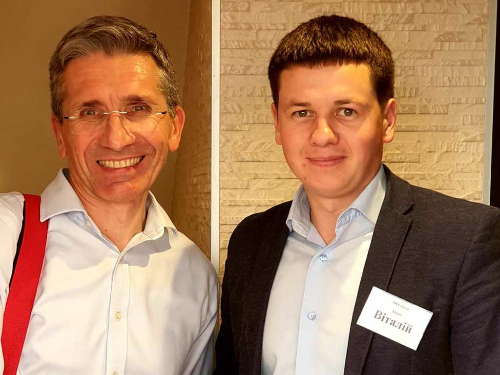 Двоє учасників професійного заходу у сфері нерухомості під час ділової зустрічі