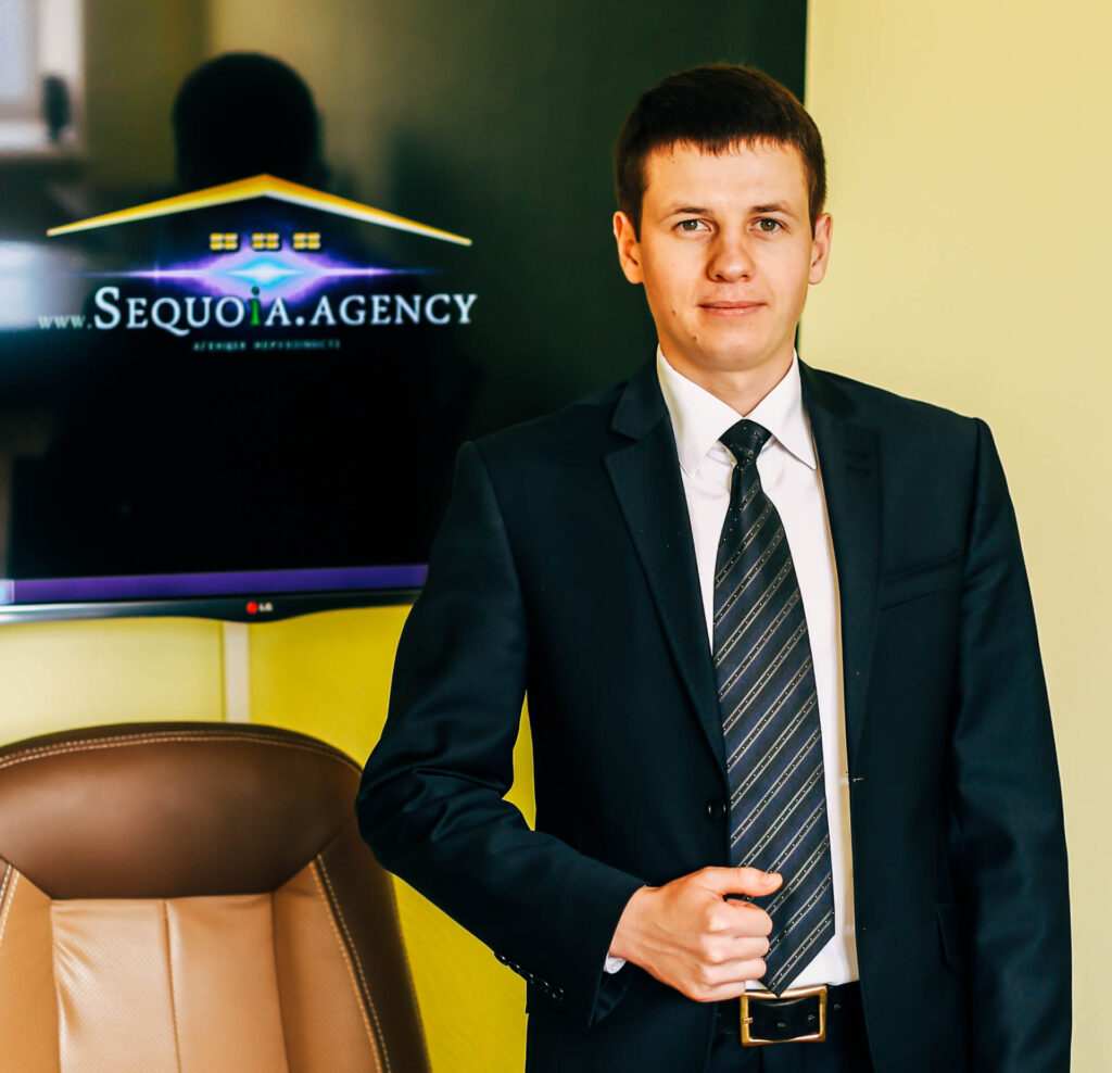Представник агенції нерухомості Секвоя в діловому костюмі в офісі